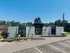 Charming modern apartment complex entrance with sleek architectural design, featuring manicured landscaping and ample parking.