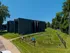 Beautiful apartment exterior with lush green surroundings and a charming fenced play area, ideal for families seeking a serene living environment.