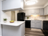Modern kitchen with sleek gray cabinets, black appliances, and elegant countertops, ideal for stylish living.