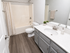 Modern bathroom with sleek fixtures, elegant vanity, and inviting tub area.