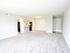 Spacious apartment with plush carpeting and open-concept design featuring a modern kitchen and ample natural light.