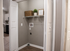 Inviting laundry nook with a built-in shelf, sleek gray walls, and a touch of greenery for a modern feel.