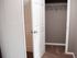 Spacious walk-in closet with ample shelving and modern white door, perfect for storage.