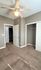Bright bedroom with plush carpeting, modern ceiling fan, and spacious closet in a stylish apartment.