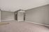 Spacious living room with plush carpet and neutral walls, ideal for versatile decor in modern apartments.
