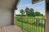 Charming balcony offering a serene view of lush greenery and blue skies, perfect for relaxation.