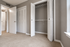 Bright bedroom featuring plush carpet and spacious closets with white louvered doors.