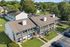 Charming apartment complex with spacious balconies, surrounded by lush greenery and a vibrant community setting.