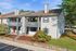 Charming apartment complex with modern architecture, featuring spacious balconies and lush landscaping.