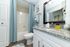 Bright and modern bathroom showcasing sleek granite countertops, elegant fixtures, and soothing blue accents.