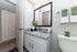 Elegant bathroom with granite countertops, large mirror, and modern fixtures, offering a serene and stylish space.