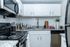 Modern kitchen with sleek granite countertops, white cabinetry, and stainless steel appliances creating a luxurious cooking space.