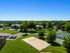 Scenic apartment complex with lush greenery, a sand volleyball court, and vibrant outdoor spaces.