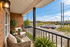 Inviting apartment balcony with cozy seating, lush greenery, and scenic view of a vibrant community.