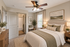 Inviting bedroom with elegant decor, featuring a cozy bed with plush pillows, a chic ceiling fan, and a serene vibe.
