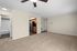 Spacious apartment with plush carpeted living area, stylish ceiling fan, and a modern kitchen with stainless steel appliances.