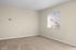 Spacious apartment with plush carpeted living area, stylish ceiling fan, and a modern kitchen with stainless steel appliances.