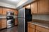 Modern kitchen with sleek stainless steel appliances, warm wooden cabinetry, and elegant countertops.
