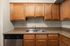 Modern kitchen with elegant wooden cabinets, sleek granite countertops, and a stainless steel dishwasher, perfect for culinary enthusiasts.