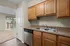 Charming kitchen with elegant wooden cabinets, stainless steel appliances, and a view of the airy living space with natural light.