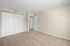 Bright and spacious primary bedroom with plush carpet, double closet doors, and a modern interior design.