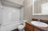 Chic bathroom with modern fixtures, featuring a spacious bathtub, elegant countertops, and ample storage space.