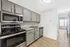 Modern kitchen with sleek stainless steel appliances, spacious grey cabinetry, and elegant granite countertops.