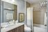 Elegant bathroom with modern fixtures, featuring a sleek vanity, large mirror, and serene decor.
