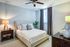 Elegant bedroom with a cozy bed, modern decor, and ample natural light, perfect for relaxation.