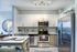 Modern kitchen with sleek stainless steel appliances, elegant cabinetry, and a cozy dining area with stylish table settings.