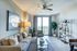 Bright and modern living room with elegant decor, a plush beige sofa, stylish glass coffee table, and expansive window offering a scenic view.