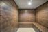 Luxurious spa-style steam room with elegant wooden paneling and soft overhead lighting, perfect for relaxation.