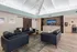 Elegant communal lounge with sleek leather sofas, modern decor, and ambient lighting under a vaulted ceiling.