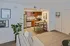 Chic apartment living space with a cozy kitchen, modern bar seating, stylish decor, and elegant plant accents.