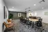 Modern conference room with sleek black chairs around a long table, stylish decor, and warm lighting creating a professional atmosphere.