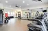 Modern gym with state-of-the-art equipment, including treadmills, punching bags, and weight machines, in a spacious, well-lit environment.