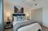 Chic and cozy bedroom featuring a plush bed with elegant cushions, stylish lamps, and modern decor.