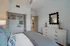 Elegant bedroom with cozy bed, modern decor, and spacious closet space, offering a serene retreat in a contemporary apartment.