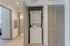 Modern apartment hallway featuring a convenient in-unit stacked washer and dryer within a sleek closet space.