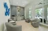 Elegant lounge area with plush gray seating, modern design, and stunning pool view through expansive windows.