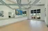 Modern exercise room with mirrored walls, ceiling fans, and vibrant artwork, perfect for a dynamic workout experience.