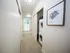 Bright hallway with elegant artwork and in-unit laundry, leading to a sunlit window view.