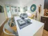 Chic modern apartment dining area with sleek white table, elegant decor, and vibrant accent rug, inviting natural light through large windows.