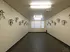 Spacious indoor bike storage room with secure wall-mounted hooks and ample lighting, perfect for cycling enthusiasts.