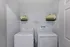 Charming laundry nook featuring modern washer and dryer with playful bee-themed baskets for stylish storage.