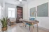 Modern home office with elegant wooden desk, stylish decor, and abundant natural light in a bright, inviting space.