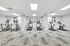 Modern fitness center featuring state-of-the-art treadmills, ellipticals, and exercise bikes in a spacious, well-lit room.
