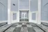 Elegant apartment lobby with high ceilings, luxurious marble flooring, and soft blue walls, offering a sophisticated entrance.