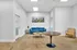 Modern sitting area with a vibrant blue sofa, wooden round table, and elegant decor enhancing the spacious, bright ambiance.
