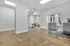 Bright office space with modern chairs, sleek white desks, and distinctive herringbone wood flooring, offering a spacious and inviting atmosphere.